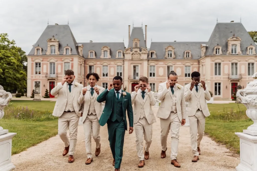 Le marié marchant avec ses témoins devant un château le jour du mariage