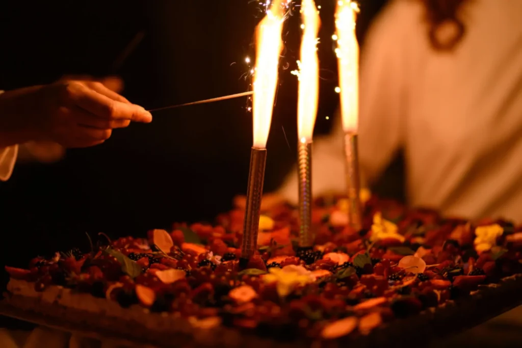 Moment festif autour d’un gâteau avec des cierges magiques lors d’un mariage